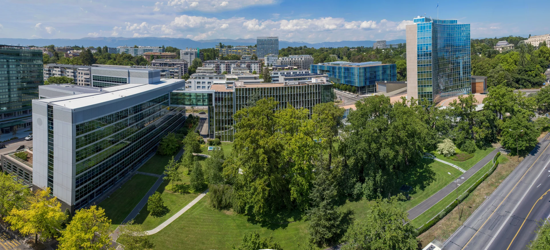 WIPO headquarters in Geneva, with glass office buildings, a conference hall and landscaped grounds.